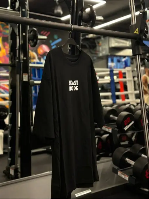Black oversized tee hanging on a gym rack