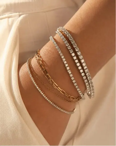 A wrist stacked with fine gold and diamond bracelets