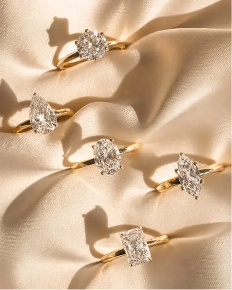 Four diamond engagement rings on cream silk