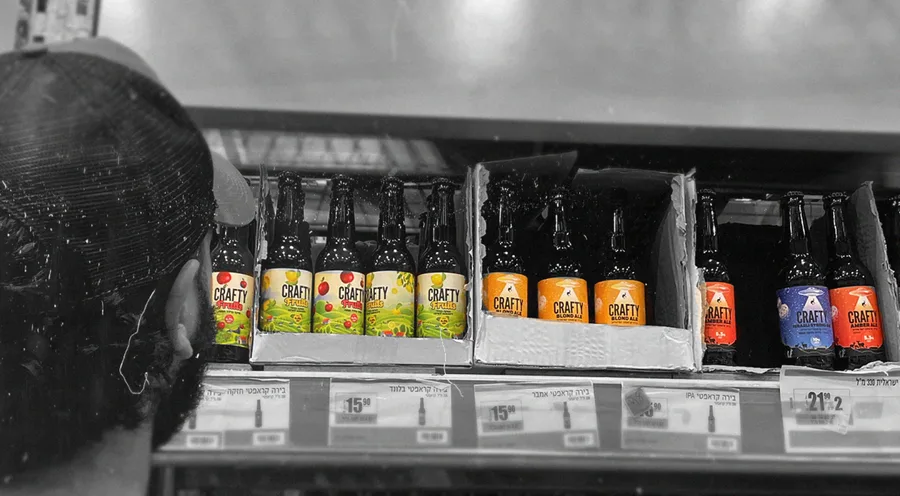 A black and white shelf of bottles and cans in a shop