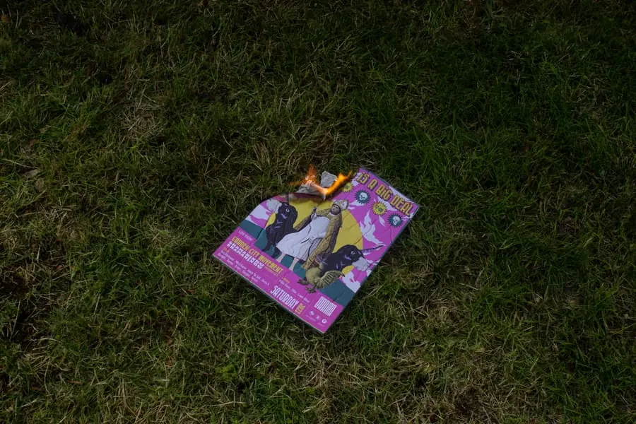 A folded poster lying on grass, second frame